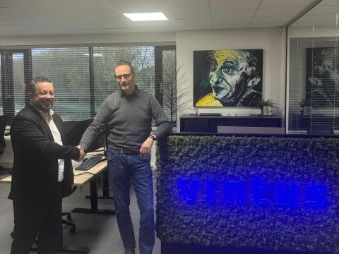 Een handdruk op het kantoor van Vintus, voor de verlichte Vintus-wand